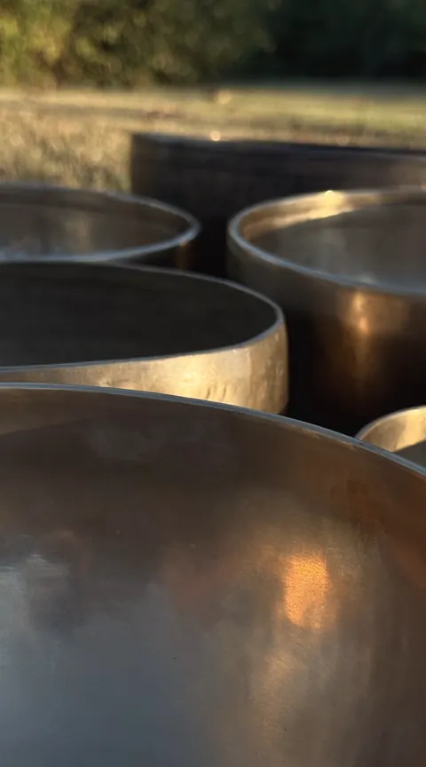 Close view of brass singing bowls glowing copper in the low evening sun